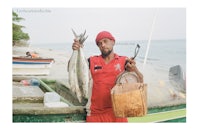 a man holding a fish on a boat